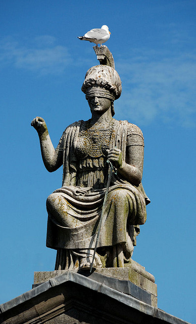 A statue of Blind Justice with her scales missing.